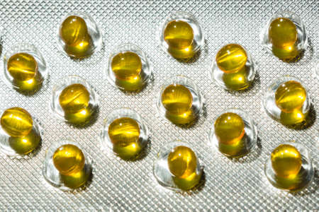 Yellow round pills in blister pack closeupの写真素材