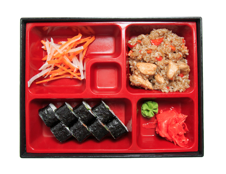 Bento lunch in the box. Set - sushi rolls, salad, pilaf, meat, sauce and wasabi. Isolated on white background.の写真素材