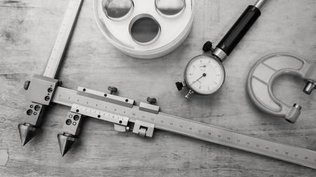 Metal measuring instruments on a wooden table. Product quality control.の写真素材