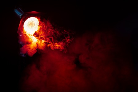 Red light with smoke on dark background. Equipment for photo Studio.