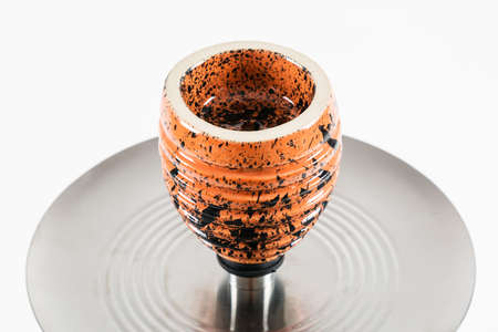 Orange hookah bowl in the shape of a beehive. White background.