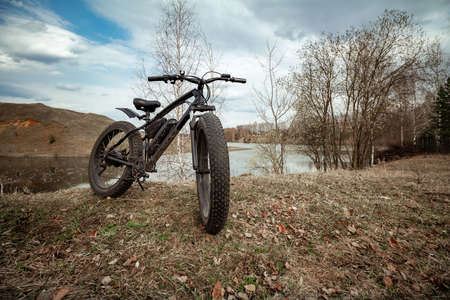 A big beautiful black bike on the shore of the lake. Healthy sports hobby.の写真素材