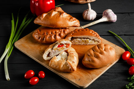 Homemade pies on a cutting board. Composition on a black background with ingredients.の写真素材