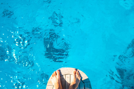 Men's feet on the bow of the ship. A man is preparing to jump into the clean blue sea. The concept of rest and pleasure.の写真素材