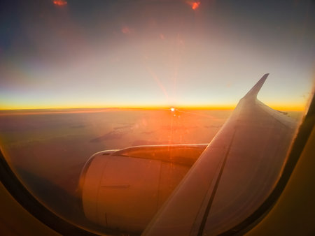 View from the plane window. Wing on the background of the sunset. The concept of vacation.の写真素材