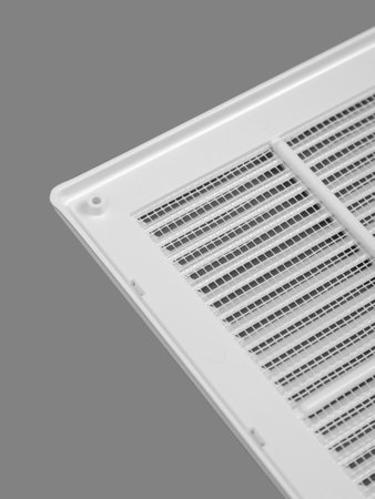 White ventilation grate on a gray background. Close-up. Material is plastic. Back side with mesh.の写真素材