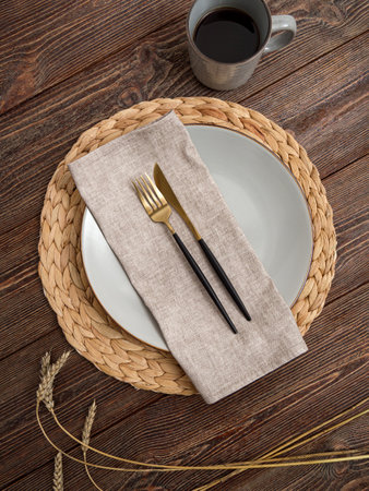 Beige napkin on a plate. Serving on a brown wooden table.の写真素材