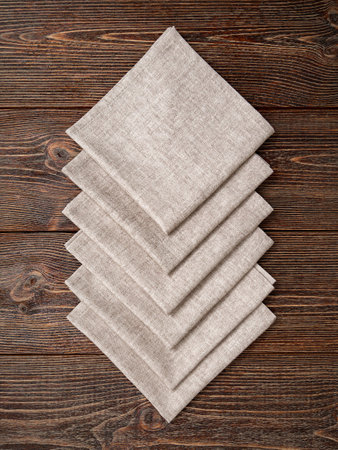 Beige napkins on a wooden brown background.の写真素材