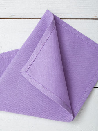 Purple napkin on a wooden white background. Closeup.の写真素材
