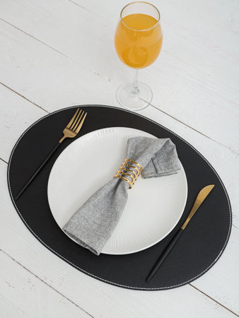 Gray napkin on a white plate. Serving on wooden table.の写真素材