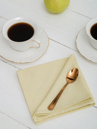 Yellow napkin on a white wooden table. Beautiful setting.の写真素材