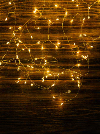 Garland glows yellow on a brown wooden background.