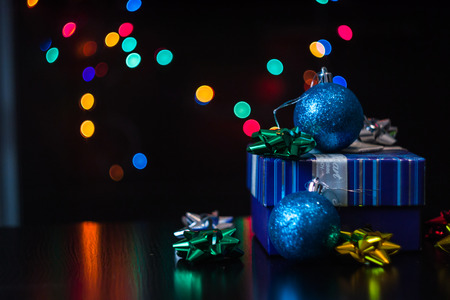 Christmas present gift box with multicolored bokeh round garland lights backgroundの写真素材