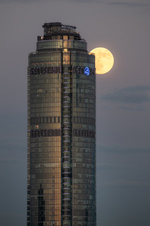 Full Moon in the evening sky behind Vysotsky skyscraper in the center of the city, Yekaterinburg, Russia. high quality photoの写真素材