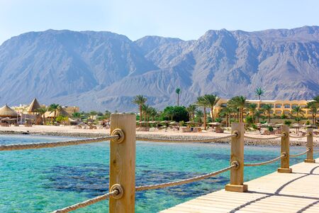 Sea, beach and mountain view from wooden bridge