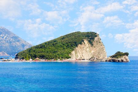 St. Nicholas island near Budva in Montenegro. Coast with blue sea, rocks and sky with clouds.の写真素材