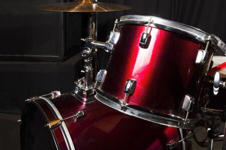 Drum set with bass and working sections, cymbals on stage with a black amp in the background.の写真素材