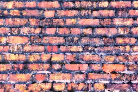 The old red brick overgrown with moss. Magically blurred texture of the wall.の写真素材