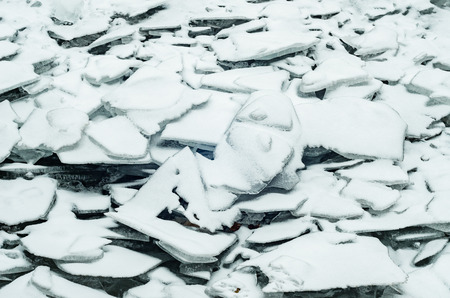 Natural broken ice blue covered with snow during freezing winter weatherの写真素材
