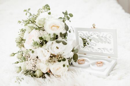 wedding rings and roses bouquet.