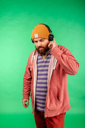 Portrait of a bright man posing in the studio on a green background. Men, beauty, colors, fashion.の写真素材