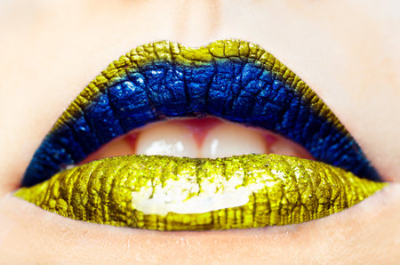 close-up of a Ukrainian woman - patriotic yellow-blue lips with gloss. Color of Ukraine. no warsの写真素材