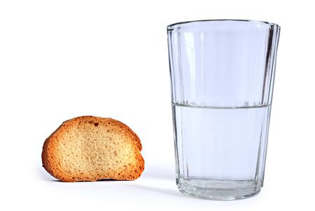dry slice of bread and glass with water isolatedの写真素材