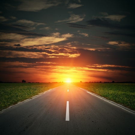 asphalt road to horizon with sunset sky の写真素材