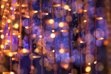 christmas festoon blurred lights background with orange and violet colorsの写真素材
