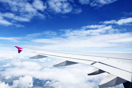 airplane wing above the clouds with blue sky on backgroundの写真素材