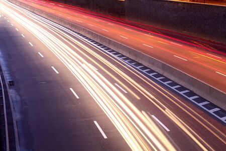 light trails of moving cars on city streetの写真素材