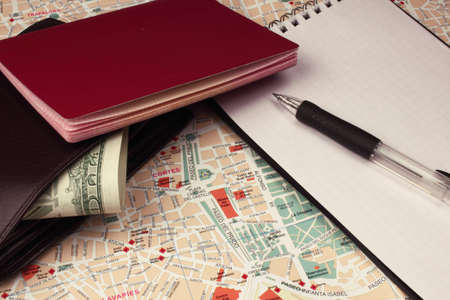 Wallet, passport,notebook and pen on city map.の写真素材