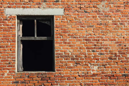 Old brick wall with broken wood windowの写真素材