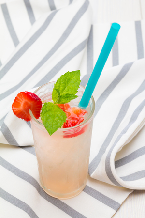 strawberry cocktail with mint leaf and straw on napkinの写真素材