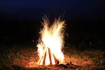 Bonfire with sparks and strong fire at night in total darknessの写真素材