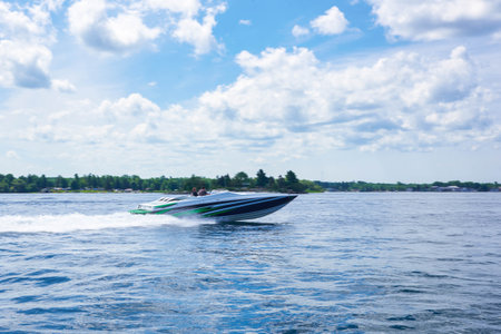 Speedboat on the river, blue sky and white clouds in the backgroundの写真素材