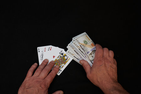 Deck of cards and money on black backgroundの写真素材
