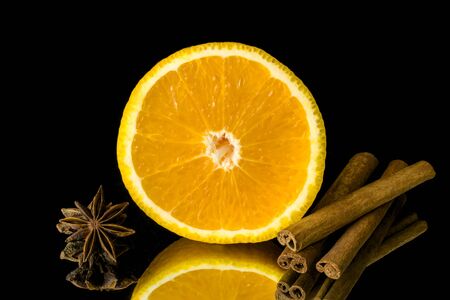 Slice of orange and cinnamon and star anise on black backgroundの写真素材