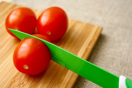 tomatoes on the board with knifeの写真素材
