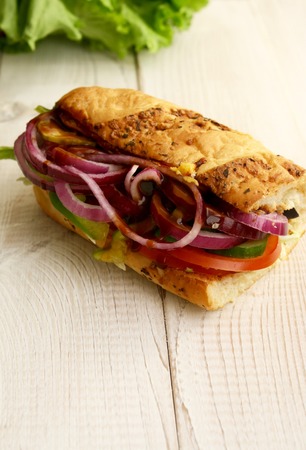 sandwiches with salad, onion, salami, pepperoni, ham, cheese and tomatoesの写真素材