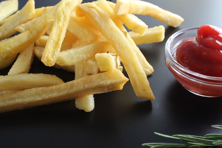 french fries and ketchup on a dark background