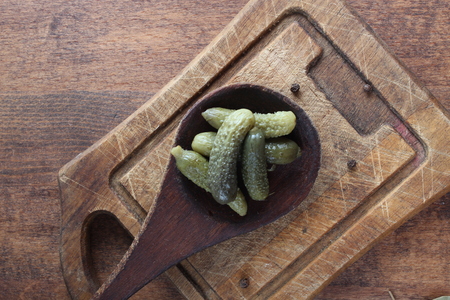 pickled cucumber cornichons on a wooden backgroundの写真素材