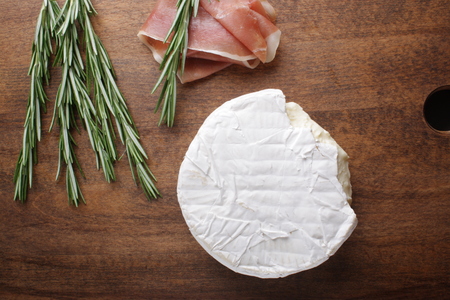 cheese brie and prosciutto ham wooden background rosemaryの写真素材