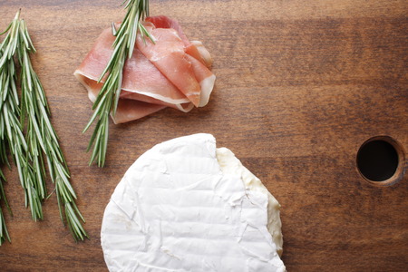 cheese brie and prosciutto ham wooden background rosemaryの写真素材