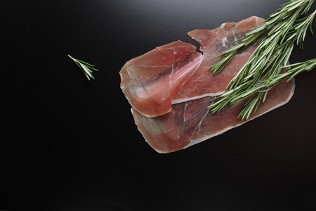 prosciutto jamon on a black background rosemaryの写真素材