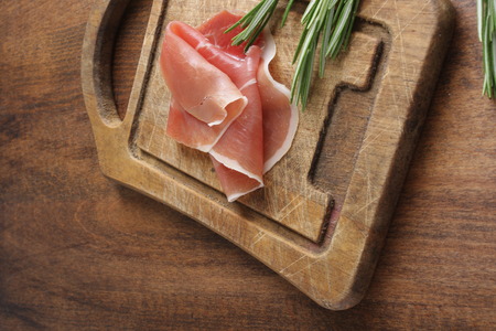 prosciutto jamon ham on a wooden background rosemaryの写真素材