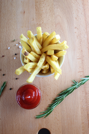French fries and ketchup on a wooden background
