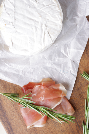 cheese brie and prosciutto ham wooden background rosemaryの写真素材
