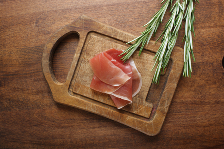 prosciutto jamon ham on a wooden background rosemaryの写真素材