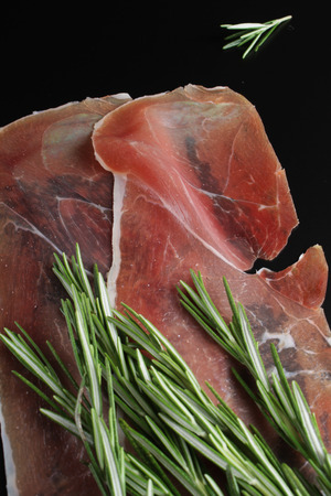 prosciutto jamon on a black background rosemaryの写真素材
